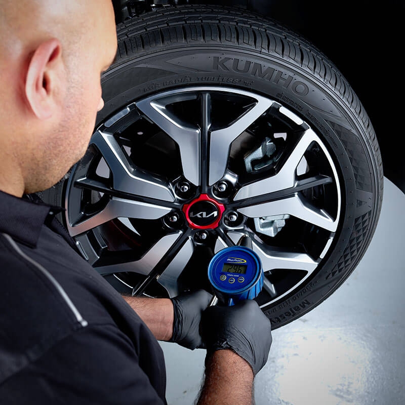 technicien Kia répare le dessous d'une voiture