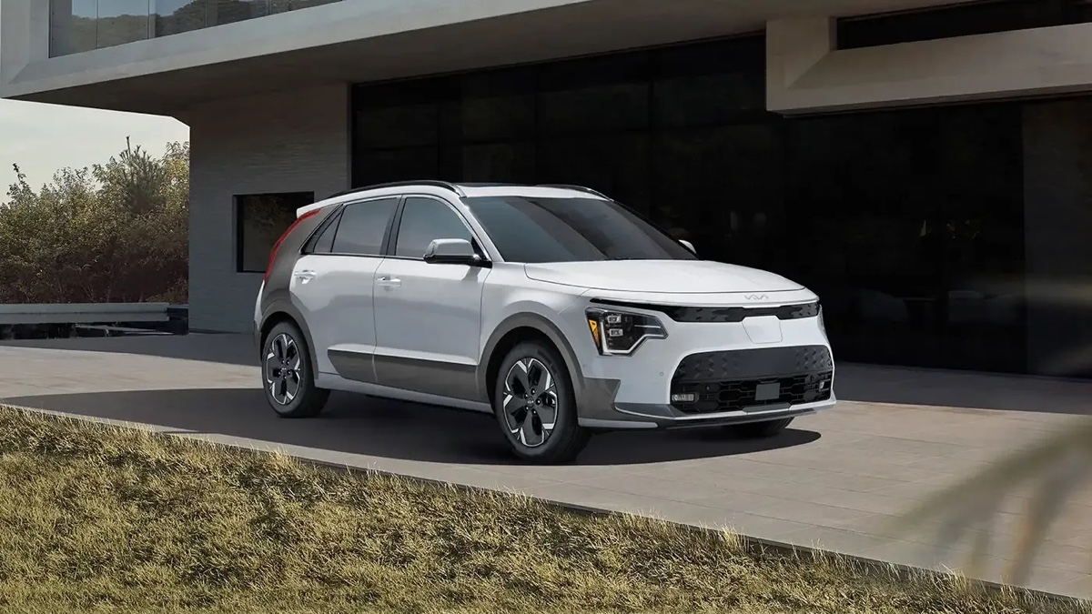 Kia Niro EV 2025 blanc stationné devant une résidence contemporaine.
