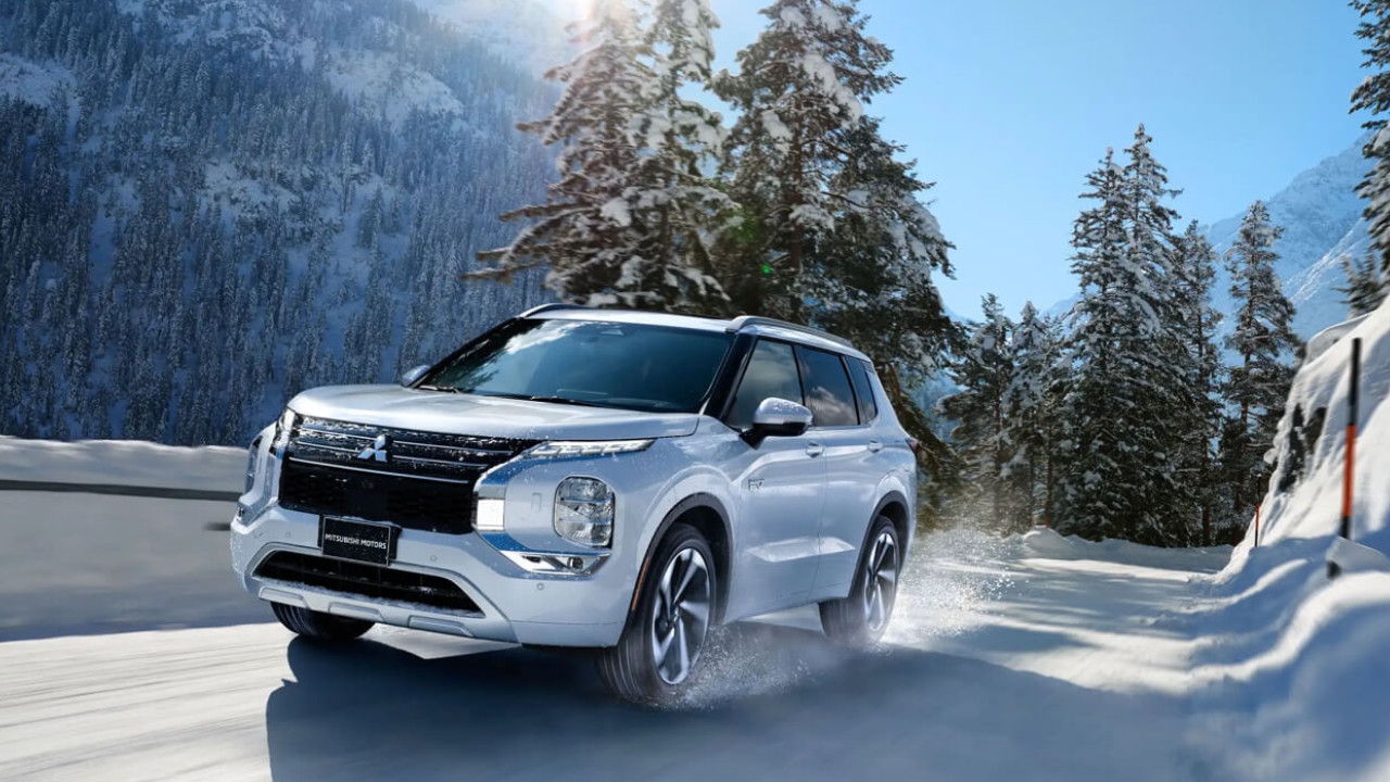 vue latérale avant d'une Mitsubishi Outlander sur une route de montagne, l'hiver